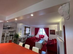 パリにあるRed Flat Parisのリビングルーム(赤いソファ、白い椅子付)