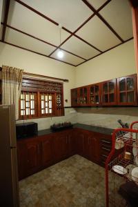 a kitchen with wooden cabinets and a counter top at Serene villa in Galle