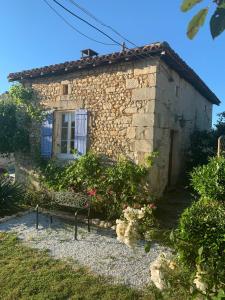 a stone house with a bench in front of it at La Marguerite in Brossac