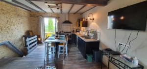 a kitchen with a counter and a table with chairs at La Marguerite in Brossac
