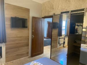 a bedroom with a sliding door and a television on a wall at Ipanema Vinicius de Moraes II in Rio de Janeiro