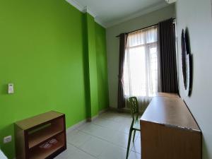Habitación verde con encimera y ventana en The Cabin Hotel Ngupasan en Yogyakarta