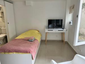 a small room with a bed and a tv at Chambre 14m2 in Massy
