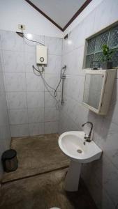 y baño con lavabo blanco y espejo. en Bay view apartment with balcony, en El Nido