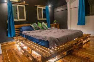 Cama de madera en habitación con cortinas azules en Bay view apartment with balcony, en El Nido