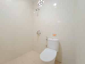 La salle de bains blanche est pourvue de toilettes et d'un robinet. dans l'établissement The Cabin Hotel Ngupasan, à Yogyakarta