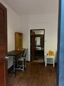 a room with a table and a kitchen with a refrigerator at Seafront Jungle Bungalow in Koh Phangan