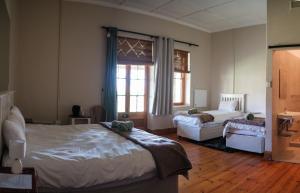 a bedroom with a bed and a couch and a window at The Border Post, Bed and Breakfast in Bergville