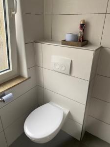 a white toilet in a bathroom with a window at Schöne Wohnung, Stadtnah & Campusnähe in Herford