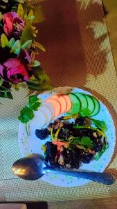 une assiette de nourriture avec des légumes et une cuillère dans l'établissement TEC Resort and bar, à Dharān Bāzār