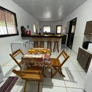 cocina con mesa y sillas en una habitación en Rochedo Casa de Praia en Nova Viçosa