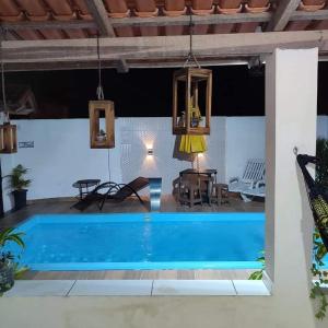 a pool in a house with a table and chairs at Rochedo Casa de Praia in Nova Viçosa