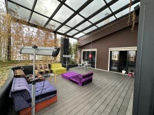 a patio with purple furniture on a wooden deck at Botanic Loft in Tirana