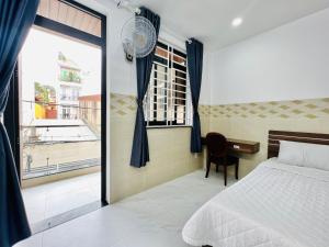 a bedroom with a bed and a desk and a window at DREAM HOUSE in Ho Chi Minh City