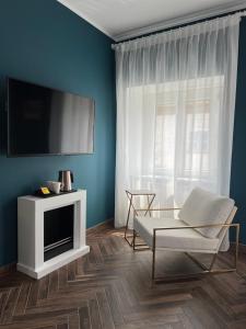 uma sala de estar com uma televisão de ecrã plano e uma cadeira em Casa Del Caval Bianco em Venaria Reale