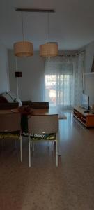 ein Wohnzimmer mit einem Tisch und einem Sofa in der Unterkunft Apartamento a 100 metros del mar in Piles