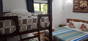 a bedroom with two bunk beds and a window at Khao Sok Holiday Resort in Khao Sok National Park