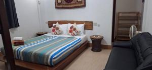 una camera con un letto, un divano e una sedia di Khao Sok Holiday Resort a Parco Nazionale di Khao Sok