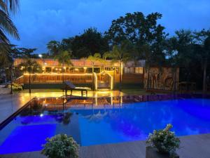 uma piscina à noite com uma fonte de água em White Land City Hotel em Dambulla