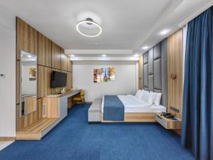 a hotel room with a bed and a television at Shymkent Park Hotel in Shymkent