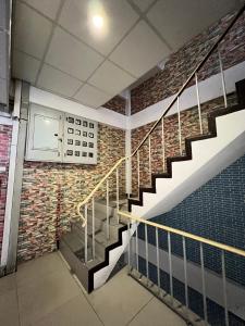 a staircase in a building with a brick wall at Natcha Place Rangsit Donmuang in Ban Talat Rangsit