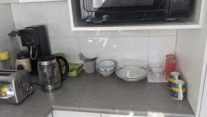 Cucina o angolo cottura di BIDWILL GARDENS ON MIDDLETON - Private Room King-Size Bed or Open Lounge Room Floor Mattress SHARED Bathroom FREE Kitchen Essentials FREE Laundry Facilities Fast NBN WIFI HDTV NETFLIX, YOUTUBE, KAYO Private Transport and Meal Services Available On Request