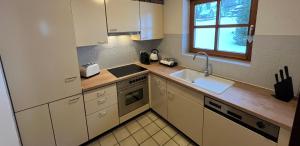 a kitchen with white cabinets and a sink and a window at Galeriewohnung in Menzenschwand in Menzenschwand-Hinterdorf