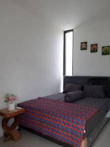 a bedroom with a bed with a blanket on it at Orange house Villa in Dau