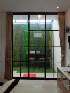 Habitación con una gran puerta de cristal y vistas al jardín. en Orange house Villa, en Dau