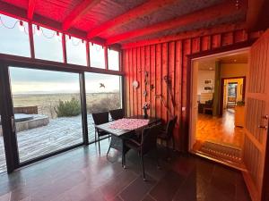a dining room with a table and a large window at Steinsholt - Birta Rentals in Hella