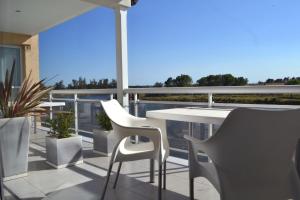 a patio with a table and chairs on a balcony at Las Barrancas Apart & Spa in Necochea