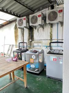 a group of air conditioners in a room with a table at Natcha Place Rangsit Donmuang in Ban Talat Rangsit
