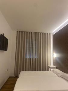 um quarto com uma cama e uma janela com cortinas em Hotel Villasegura em Molina de Segura