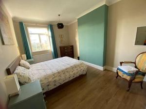 a bedroom with a bed and a chair and a window at Wellbet Farm in Lincoln