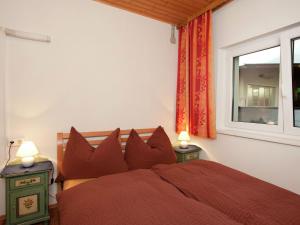 een slaapkamer met een rood bed en een raam bij Spacious flat with balcony in Mittersill in Mittersill