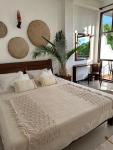 a bedroom with a large bed and a plant at MIRISSA Reef Serenity in Mirissa