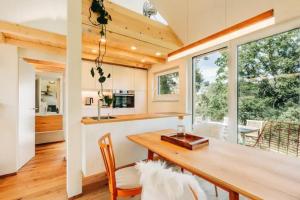 a kitchen and dining room with a wooden table and chairs at Tinyhouse Minimalus Panorama Schlafloft im Grünen in Dessighofen