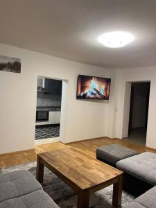 a living room with a table and a tv on the wall at Wohnung in Hüttau in Sonnberg