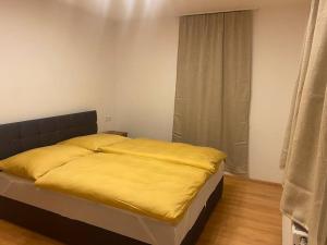a bedroom with a bed with yellow sheets and a window at Wohnung in Hüttau in Sonnberg