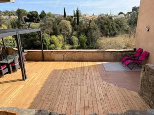 two pink chairs sitting on a patio with a view at Love Room du Moulin Rose in Trans-en-Provence