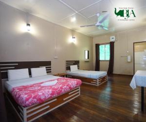 sypialnia z 2 łóżkami i wentylatorem sufitowym w obiekcie Borneo Jungle Adventure w mieście Kinabatangan