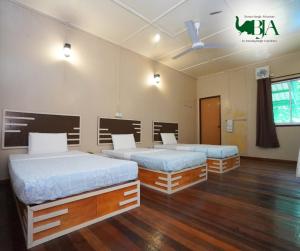 two beds in a room with wooden floors at Borneo Jungle Adventure in Kinabatangan