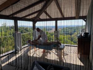 un hombre sentado en una mesa en un balcón en Cascina GianTino G A Y - ONLY suite Sughero en Montegrosso dʼAsti