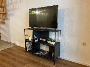 TV de pantalla plana en un centro de entretenimiento negro en Galeriewohnung in Menzenschwand, en Menzenschwand-Hinterdorf