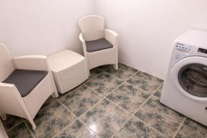 een wasruimte met een wasmachine en stoelen bij Casa Andrea Doria Arinaga in Arinaga