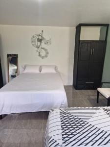 a bedroom with a white bed and a black cabinet at Amharic in Kingston