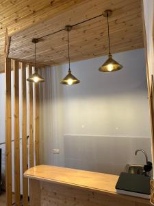 eine Küche mit drei Lichtern, die von der Decke hängen in der Unterkunft Teona's Guesthouse in Mestia in Mestia