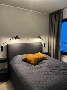 ein Schlafzimmer mit einem Bett mit zwei Lampen und einem Fenster in der Unterkunft Saaga Ylläs Chalet 3304 in Ylläsjärvi