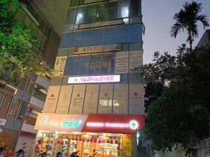 Un palazzo alto con un cartello di fronte a un negozio di Hotel Ritz Vesu - Hotels in Vesu, Surat a Surat