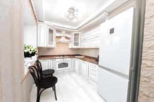 uma cozinha com armários brancos e uma cadeira preta em Центр Яворницкого с Джакузи em Dnipro